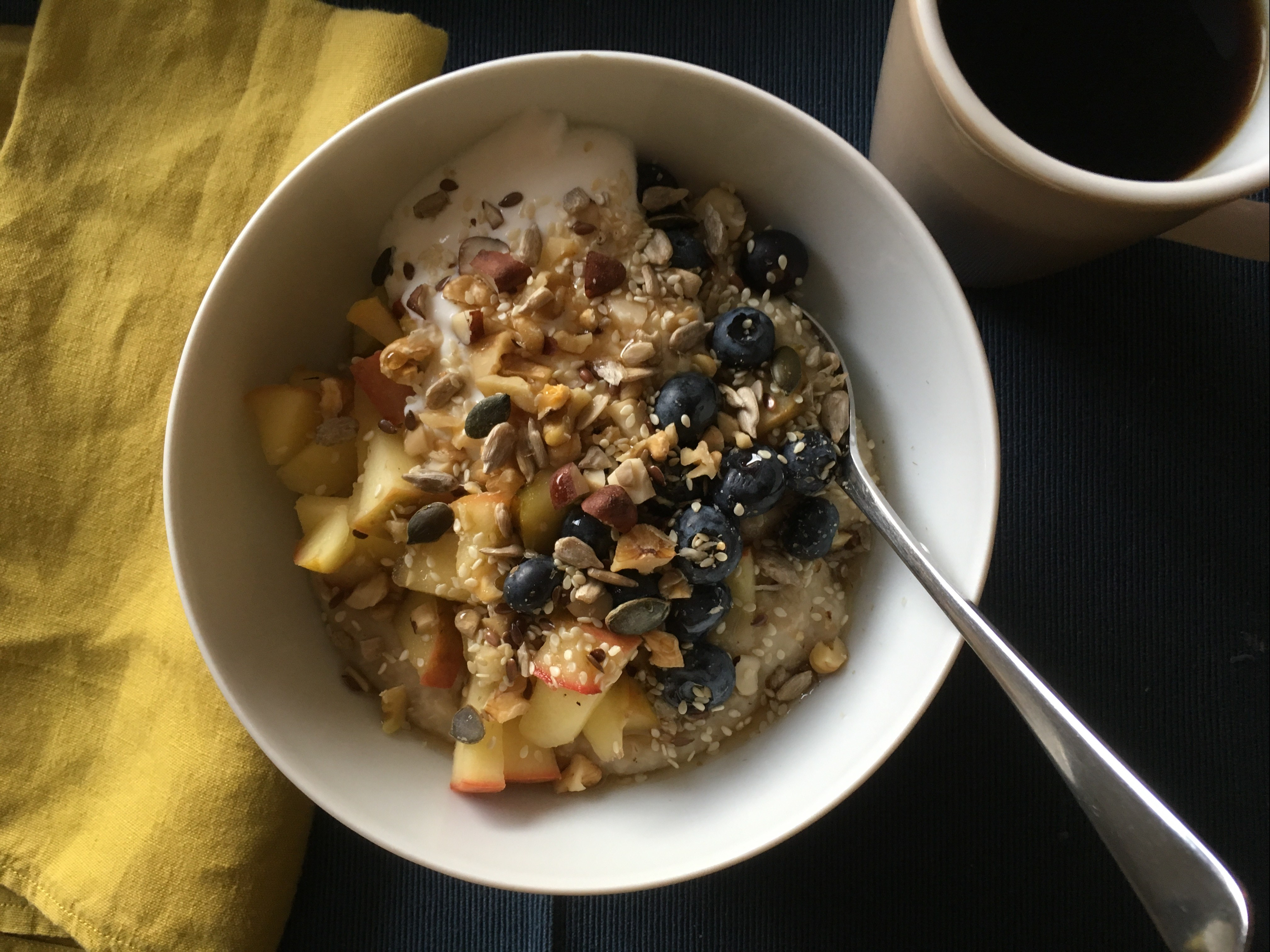Porridge with apple compote, blueberries, nuts and seeds
