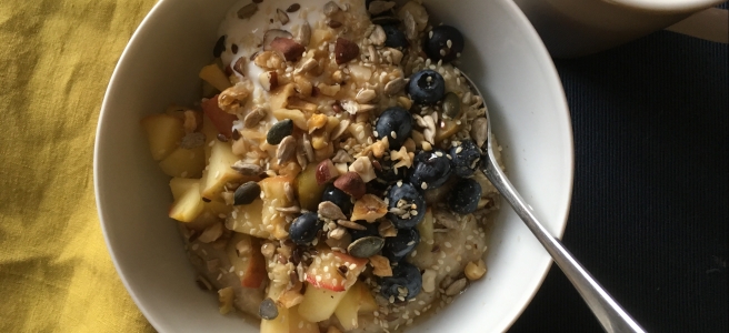 Proper porridge with apple compote, blueberries, nuts and seeds